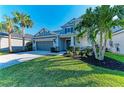 Two-story home with a gray facade, well-manicured lawn, and a two-car garage at 5709 Sunflower Cir, Sarasota, FL 34238