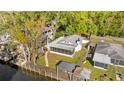 Aerial view of property with dock on the water, screened porch, and fenced yard at 6201 Waverly Rd, Weeki Wachee, FL 34607