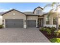 Charming gray home featuring a brick driveway, well-kept lawn, and a gray tile roof at 7717 Mainsail Ln, Sarasota, FL 34240
