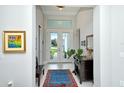 Bright foyer features tile flooring, an area rug, artwork, and French doors offering a glimpse of the outdoors at 7744 Sandhill Lake Dr, Sarasota, FL 34241