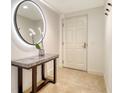 Elegant entryway features a marble-topped table, lighted mirror, and tiled floor at 800 N Tamiami Trl # 1506, Sarasota, FL 34236