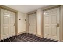 Hallway showing neutral-toned doors with bronze-colored hardware and striped carpeting at 800 N Tamiami Trl # 1506, Sarasota, FL 34236