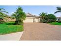 The home's exterior features a three-car garage, brick paved driveway and meticulous landscaping at 8007 River Preserve Dr, Bradenton, FL 34212