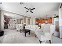 This living room opens to the kitchen and features ample seating and a ceiling fan at 8007 River Preserve Dr, Bradenton, FL 34212