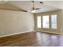 Open living space with wood floors, high ceilings, a ceiling fan, and natural light from windows at 8314 Drolet Ave, North Port, FL 34291