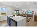 View of kitchen island with stainless steel dishwasher and sink overlooking the dining and living room at 8330 Abalone Loop, Parrish, FL 34219