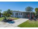 Charming home features well-maintained landscaping, a cozy covered porch, and a paved driveway at 8409 Imperial Cir, Palmetto, FL 34221