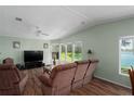 Inviting living room featuring wood floors, large windows with lake views, and comfortable seating at 8409 Imperial Cir, Palmetto, FL 34221