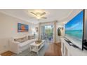 Cozy living room featuring a sofa, entertainment center, and access to the outdoor patio at 850 S Tamiami Trl # 307, Sarasota, FL 34236