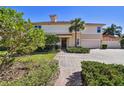 Beautiful home featuring a well-manicured lawn, a red brick driveway, and lush landscaping at 9441 Discovery Ter # 101A, Bradenton, FL 34212