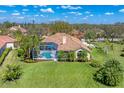 Aerial view of a home showcasing a screened-in pool and lush green backyard under a clear blue sky at 9612 Old Hyde Park Pl, Bradenton, FL 34202
