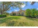 Charming home with manicured lawn, lush landscaping, and a beautiful tile roof creating inviting curb appeal at 9612 Old Hyde Park Pl, Bradenton, FL 34202