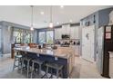 Bright kitchen with large center island, granite countertops, stainless steel appliances, and white cabinetry at 10820 Daybreak Gln, Parrish, FL 34219