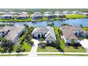 Stunning aerial view of the home nestled within a waterfront community with lush landscaping and private docks at 11511 Harbourside Ln, Parrish, FL 34219