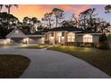 Inviting home with a circular drive, manicured landscaping, and a three-car garage at sunset at 13608 11Th E Ter, Bradenton, FL 34212