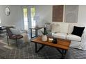 Bright living room with modern decor, a white sofa, and a decorative rug at 1397 43Rd St, Sarasota, FL 34234