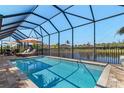 Relaxing screened-in pool area with comfortable lounge furniture overlooking the water at 16211 Cayman Ln, Punta Gorda, FL 33955