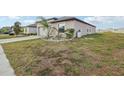 Tan home showcasing a spacious lawn, complemented by fresh landscaping at 16621 Sunburst Lake St, Wimauma, FL 33598
