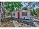 Adorable home with a red door, complemented by a cozy patio area perfect for outdoor relaxation at 1664 10Th St, Sarasota, FL 34236