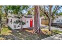 Quaint home with a red door surrounded by mature trees, offering privacy and curb appeal at 1664 10Th St, Sarasota, FL 34236