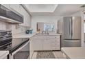Bright kitchen featuring white cabinetry, modern appliances, and a window view of the outdoors at 2446 Clubhouse Cir # 202, Sarasota, FL 34232