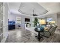 Bright living room featuring wood floors, tray ceilings, and access to outdoor pool area at 26800 Pavin Dr, Englewood, FL 34223