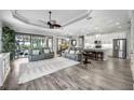 Open-concept living room featuring modern decor, wood floors, and a view of the pool area at 26800 Pavin Dr, Englewood, FL 34223
