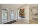 Inviting foyer with bright tile flooring, decorative artwork, and a glass front door, creating an elegant entrance at 3151 Bayou Sound, Longboat Key, FL 34228