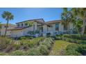 Beautiful home with lush landscaping, a charming entrance, a tile roof, and a two-car garage on a sunny day at 3151 Bayou Sound, Longboat Key, FL 34228