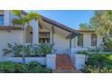 Inviting home exterior featuring a landscaped yard and a charming gated entryway, complemented by a well-manicured tropical palm at 3151 Bayou Sound, Longboat Key, FL 34228