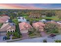 Aerial view of homes with red tile roofs, manicured lawns, and a tranquil pond in a residential community at 3715 80Th E Dr, Sarasota, FL 34243