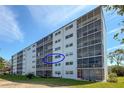 The building's exterior with large windows and balconies, surrounded by greenery and clear skies at 4240 Ironwood Cir # 302A, Bradenton, FL 34209