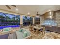 Cozy outdoor dining area featuring a full kitchen, comfortable seating, and a view of the sparkling pool at 4717 Zeno Ct, Bradenton, FL 34211