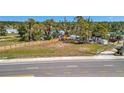 Large open lot surrounded by a wood fence with a road in front at 5061 Placida Rd # A, Englewood, FL 34224
