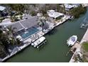 Aerial view of a waterfront home, showcasing its screened-in pool, private dock, and boat lift on a canal at 552 Juan Anasco Drive, Longboat Key, FL 34228