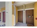 Charming townhouse entrance featuring colorful accent walls, a welcome mat and a wreath at 5601 Bentgrass Dr # 10-115, Sarasota, FL 34235