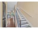 Inviting hallway with wood floors leads to a modern kitchen and staircase at 5601 Bentgrass Dr # 10-115, Sarasota, FL 34235