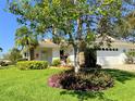 Well-maintained home with a lush lawn, mature landscaping, and an attached garage at 5638 Garden Lakes Palm, Bradenton, FL 34203