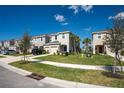 A row of townhomes with manicured lawns and young trees under a sunny sky at 5734 Archipelago St, Nokomis, FL 34275