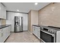 Modern kitchen features stainless steel appliances, white cabinets, and sleek countertops at 5757 Gulf Of Mexico Dr # 110, Longboat Key, FL 34228
