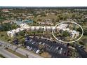 A condo complex features parking and outdoor amenities like a pool and tennis court nestled among mature landscaping at 618 Bird Bay S Dr # 118, Venice, FL 34285