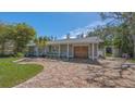 Inviting home exterior featuring a brick driveway, well-kept lawn, and mature trees at 618 Buttonwood Dr, Longboat Key, FL 34228