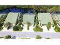 Aerial view of the townhome with a green roof, lush landscaping, and a serene lake in the background at 8536 54Th Avenue E Cir, Bradenton, FL 34211
