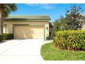 Charming front exterior with a well-manicured lawn, colorful landscaping, and attached two-car garage at 8536 54Th Avenue E Cir, Bradenton, FL 34211