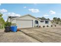 Charming single-story home with a two-car garage, neutral paint scheme, and a row of potted plants in front of the windows at 928 Spindle Palm Way, Apollo Beach, FL 33572
