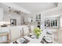 Bright and airy dining area open to a gourmet kitchen featuring a large island and stainless steel appliances at 106 N Blvd Of The Presidents, Sarasota, FL 34236