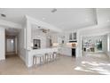 Open-concept kitchen featuring a breakfast bar, wine storage and views into the pool area at 106 N Blvd Of The Presidents, Sarasota, FL 34236