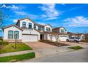 Inviting townhome showcasing a two-car garage, lush lawn, and paved driveway under a clear blue sky at 11831 Brookside Dr, Bradenton, FL 34211