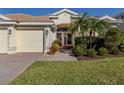 Charming single-story home with a three-car garage, an arched entryway, and a well-manicured lawn at 12022 Granite Woods Loop, Venice, FL 34292
