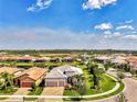 Expansive aerial view of a gray tile-roofed home, showcasing its pristine landscaping and tranquil neighborhood at 12448 Golden Sage Dr, Sarasota, FL 34238